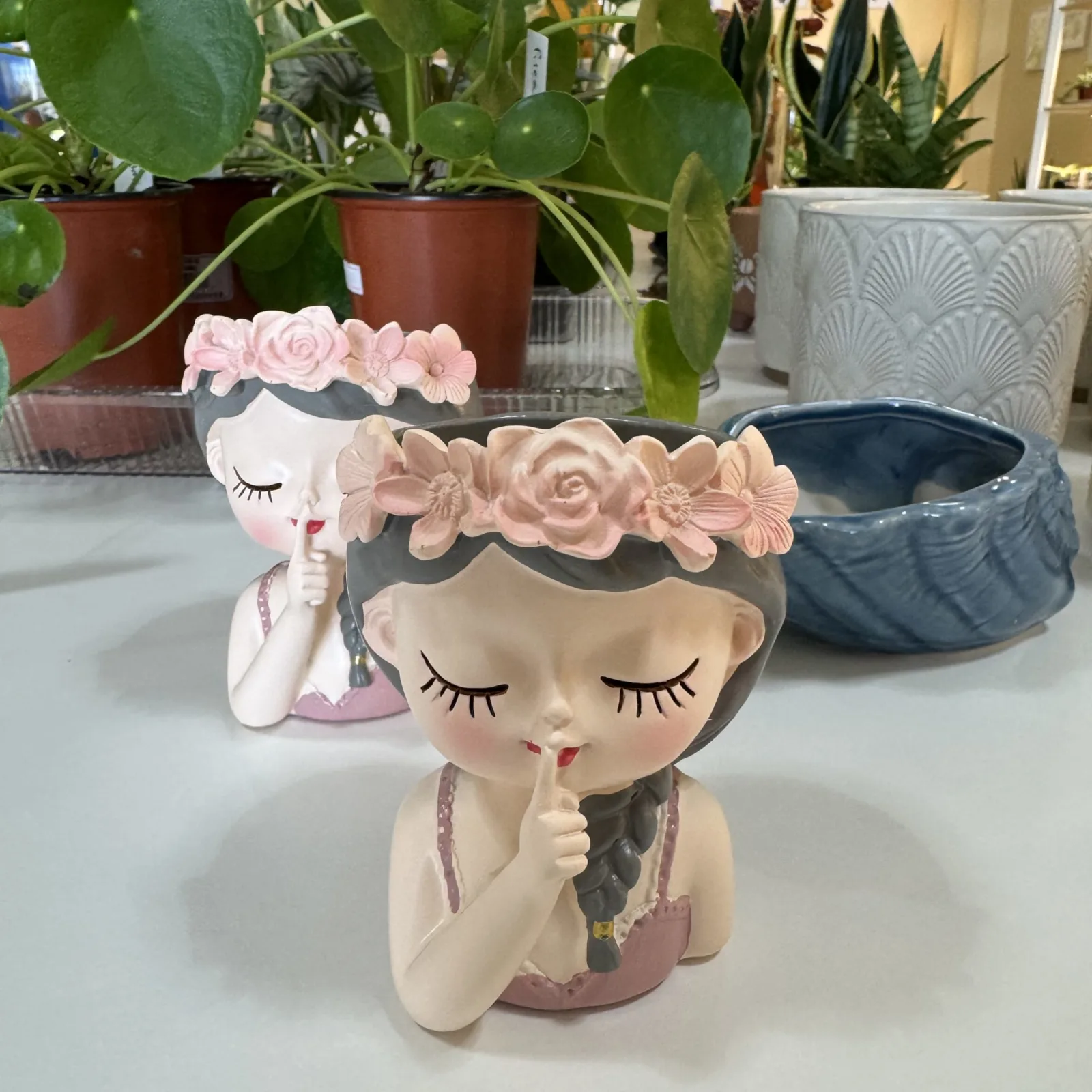 Face Plant Pot with closed eyes, flower crown, ceramic planter featuring decorative floral details.