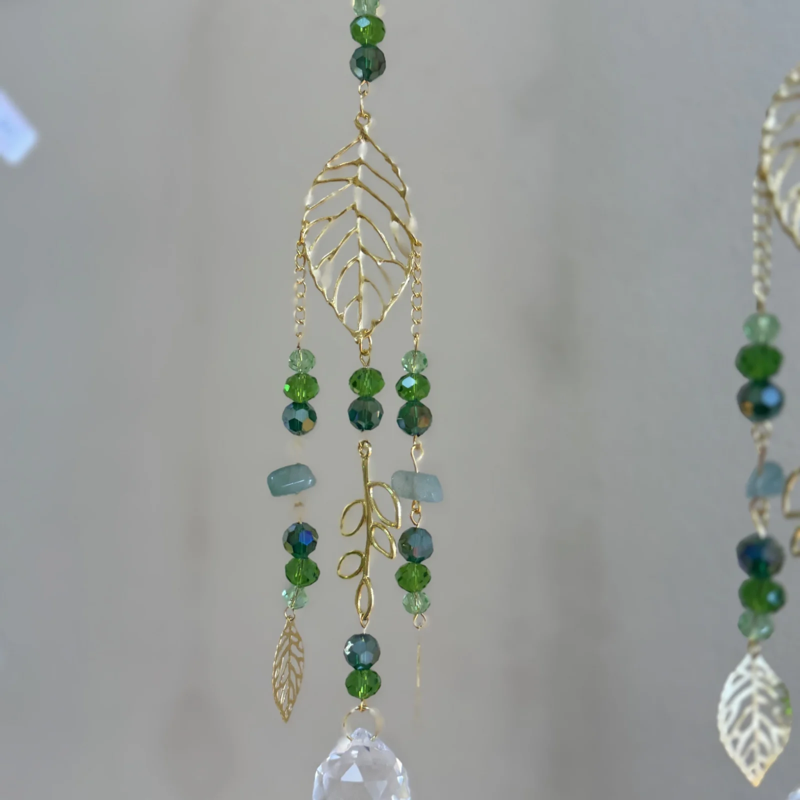 Monstera Leaf Sun Catcher with green beads and crystal prism hanging decoration.