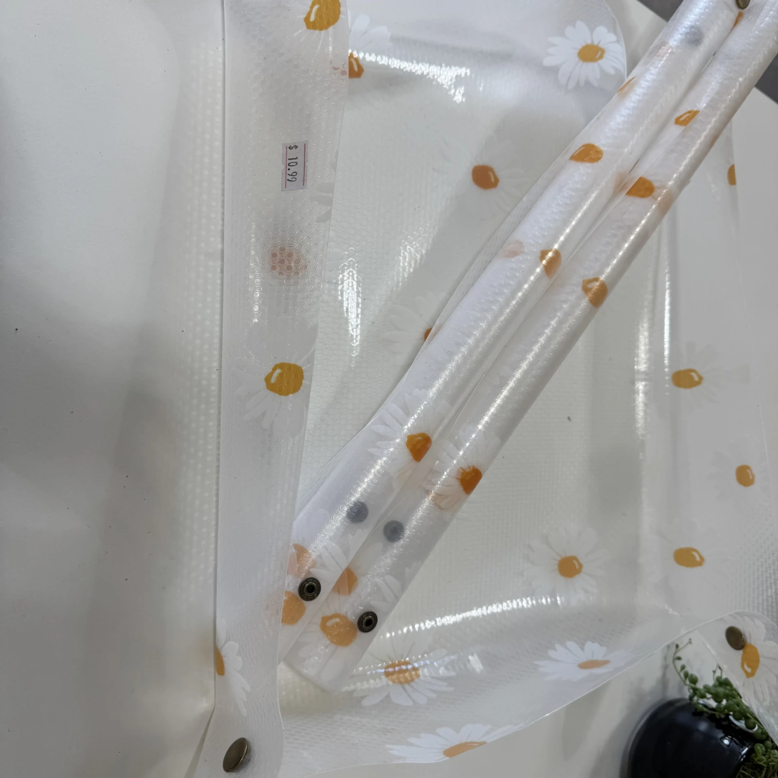 Potting Mat with clear protective covering and scattered soil particles on white surface.