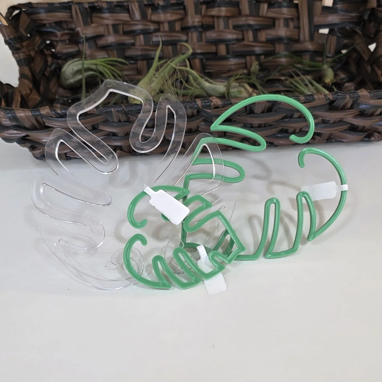 Plant Stem Support clips in clear and green colors displayed on white surface with basket.