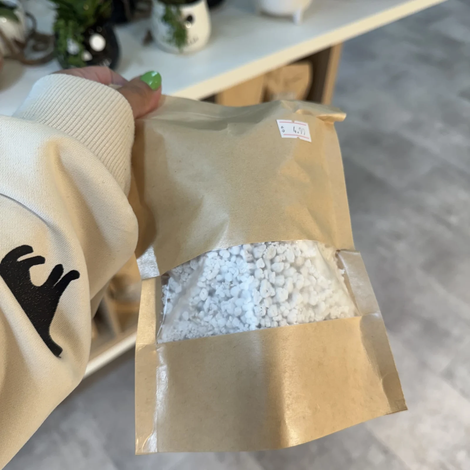 Perlite white mineral granules in open kraft paper packaging bag.