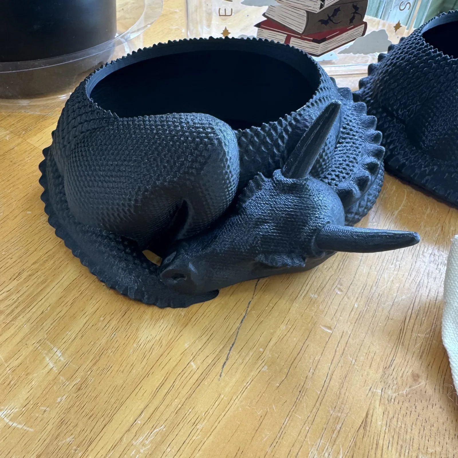Dragon Plant Pot with black textured ceramic planter shaped like dragon head on wooden surface.