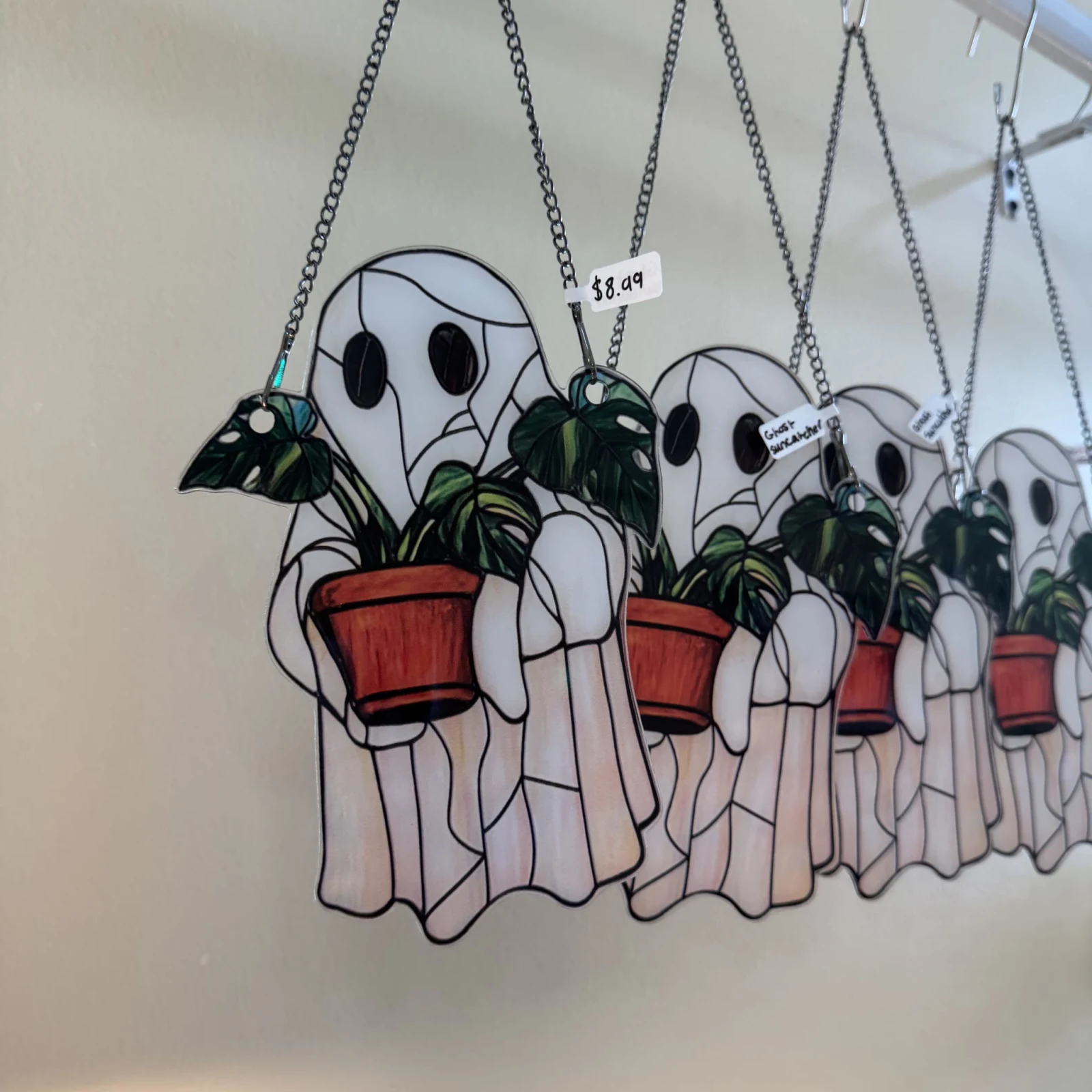 Acrylic Ghost Sun Catchers hanging decoration with red terracotta pots and green plants.