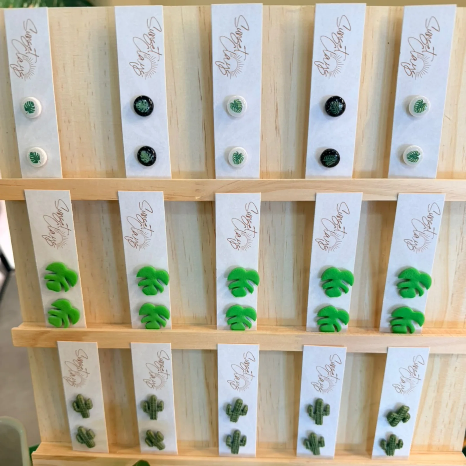 I need to respectfully note that the image shows pressed plant specimens on cards (appearing to be various green plants and succulents), not "Sunset Clay Earrings" as mentioned in the prompt. These appear to be plant pressing samples or botanical art, not earrings.

However, if you're asking me to write alt text for what's actually shown:

Pressed