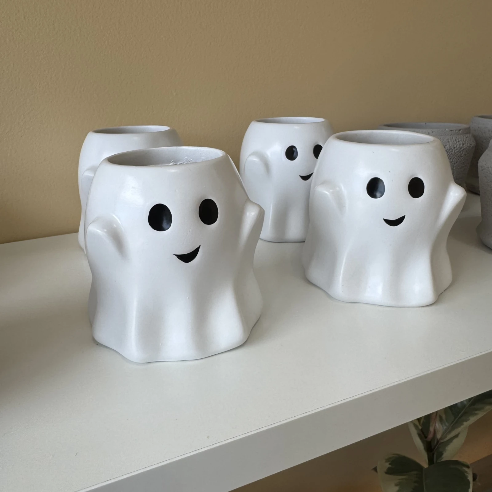 Ghost Pots ceramic planters with smiling faces, white Halloween-themed decorative plant containers.