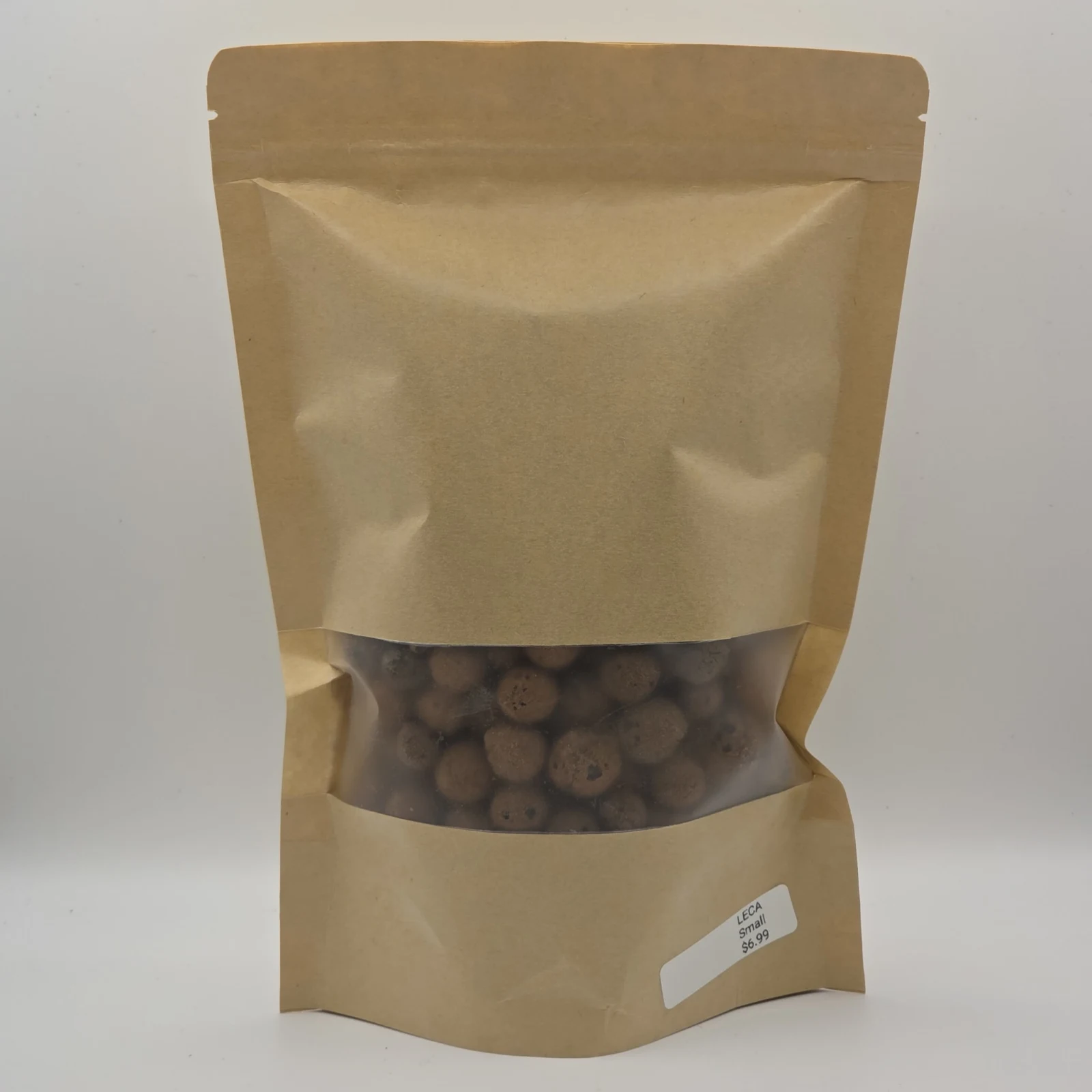 Leca clay balls in kraft paper resealable pouch with transparent window.