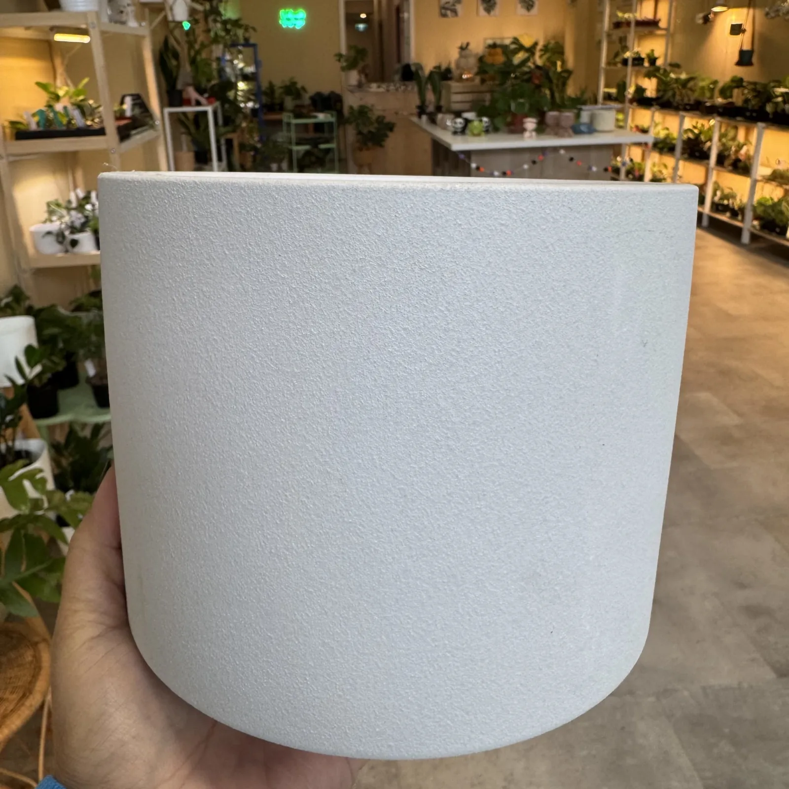 White clay pot displayed in plant nursery showroom setting