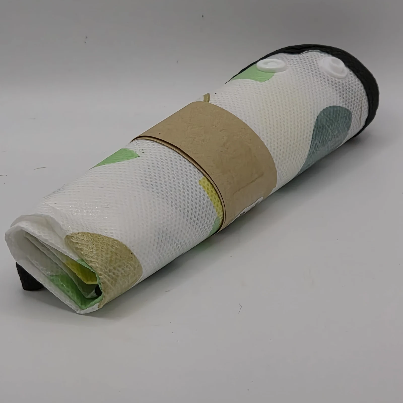 Potting Mat with clear protective covering and scattered soil particles on white surface.