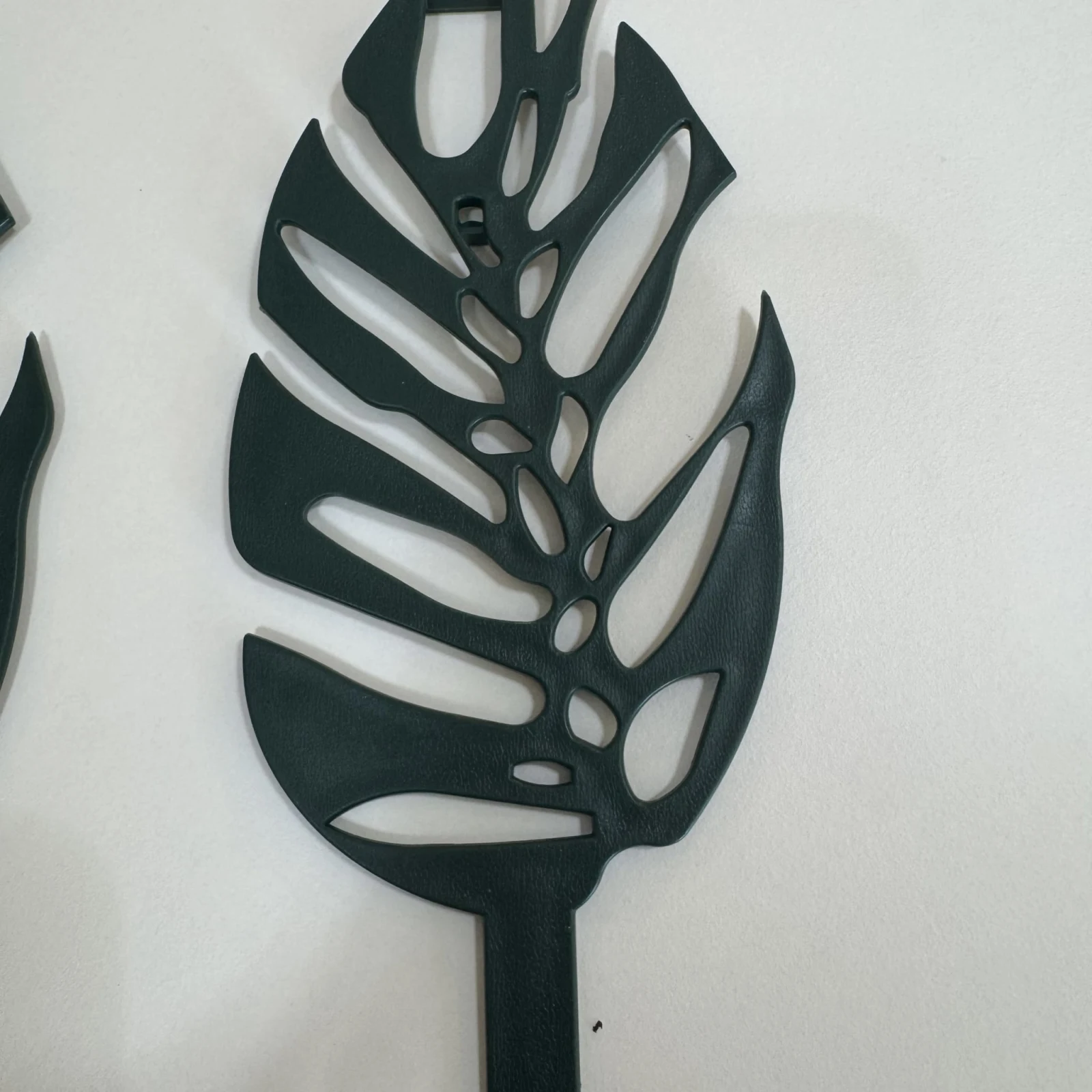 Monstera Leaf Trellis plant support with black metal cutout leaf design on white background.