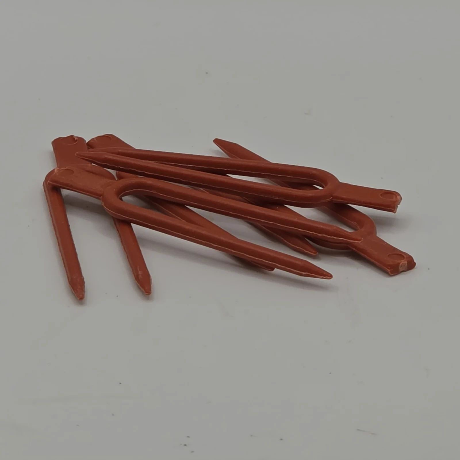 Plant Forks garden tool set in terracotta red, multiple pronged stakes for soil support.