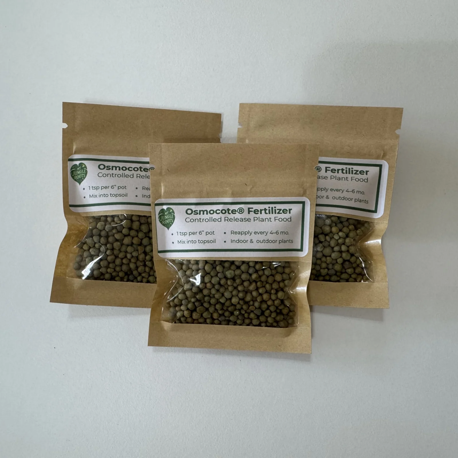 Osmocote Fertilizer controlled release plant food in three kraft paper pouches with pellets.