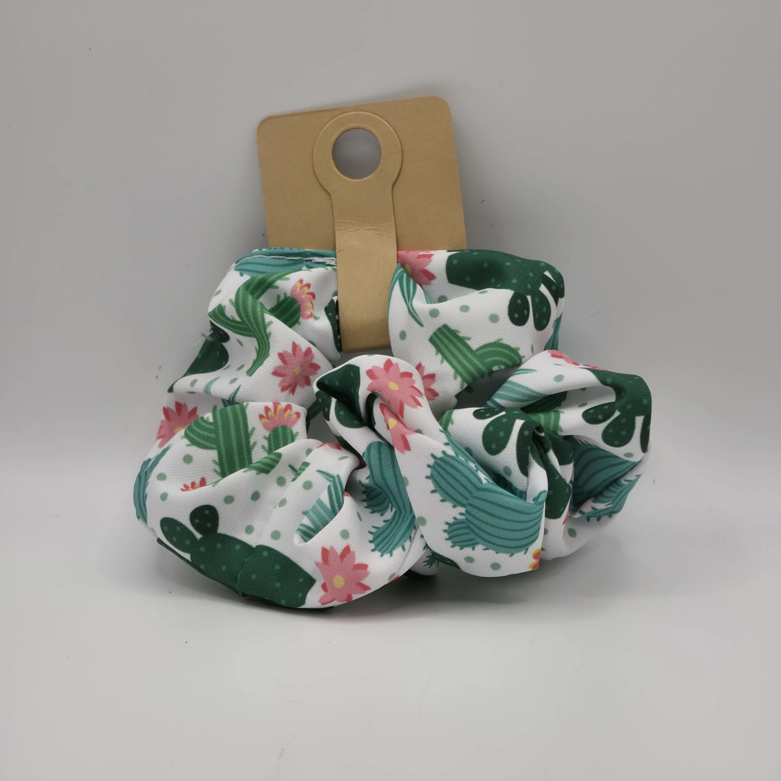 Planty Scrunchies with cactus and pink flower fabric design on wooden holder.