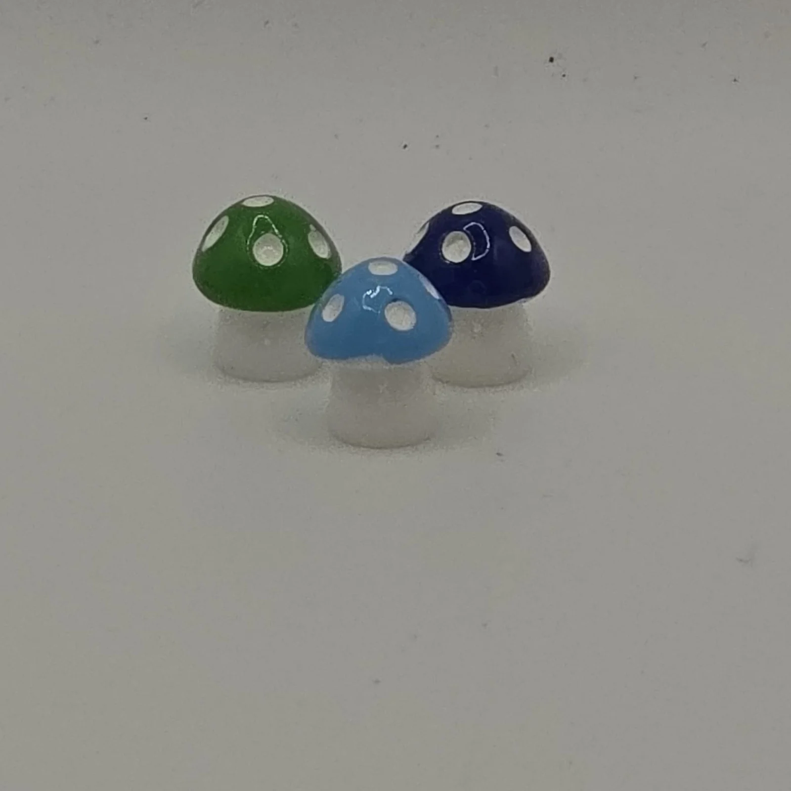 Resin Mushroom decorative figurines in green, blue, and navy with white spots and stems.